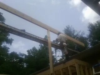 Carpenter setting a ridge beam over a new addition frame — Ice Dam Removal by Roofing Brothers in Abington