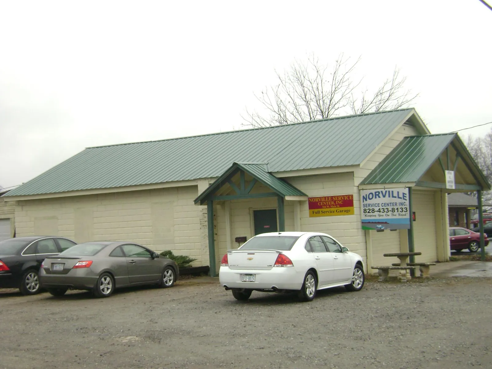 Green metal roof on a service garage with a covered entry in Abington